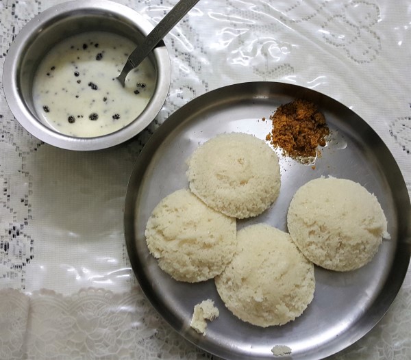 Idli served with spicy, watery coconut chutney